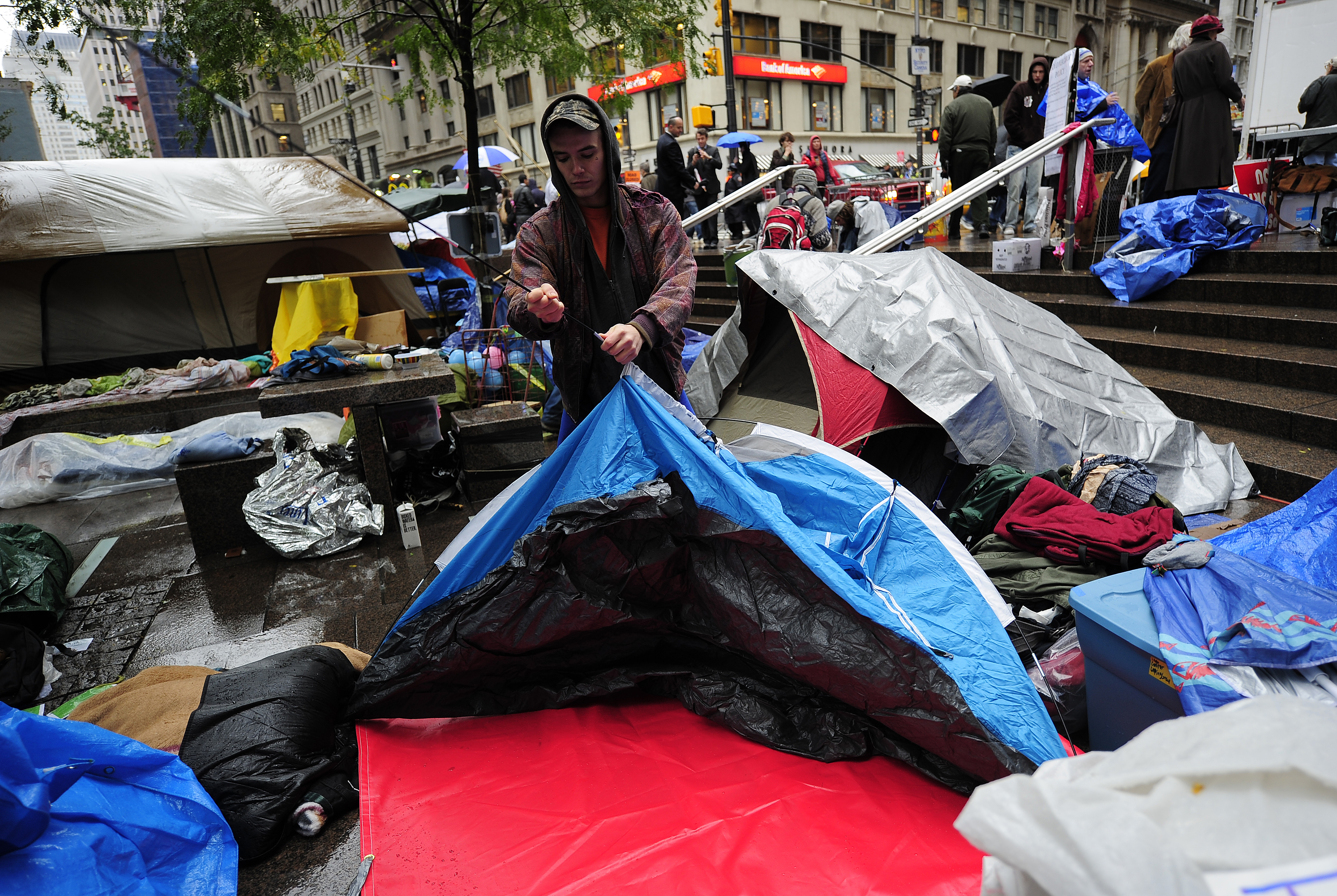 An Occupy Wall Street member sets up a tent 