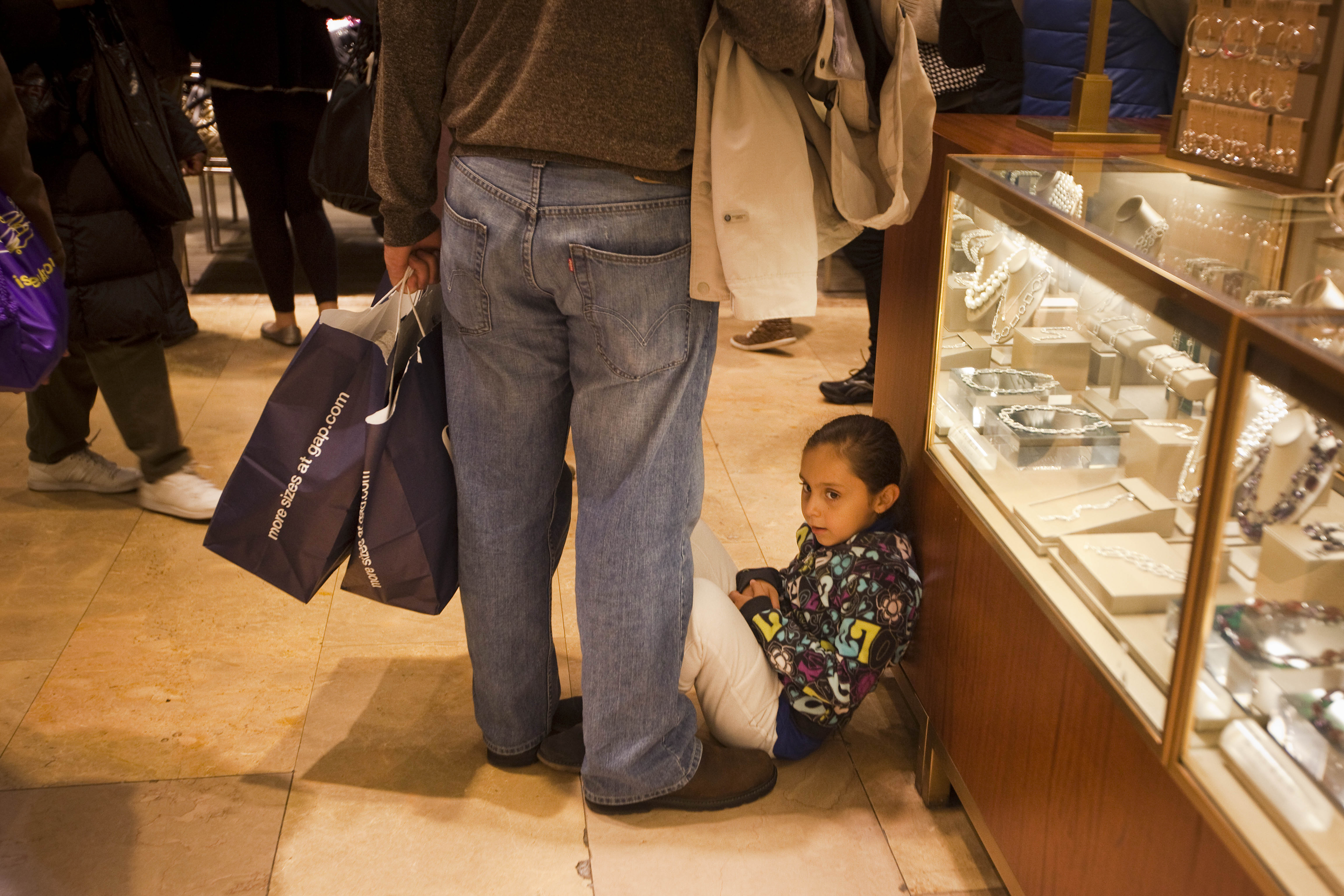 Child waits for parent to finish Black Friday shopping 