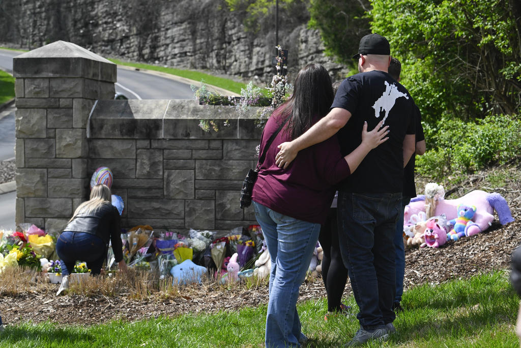People gather at an entry to Covenant School, which has become a memorial for shooting victims, March 28, 2023, in Nashville, Tenn. 
