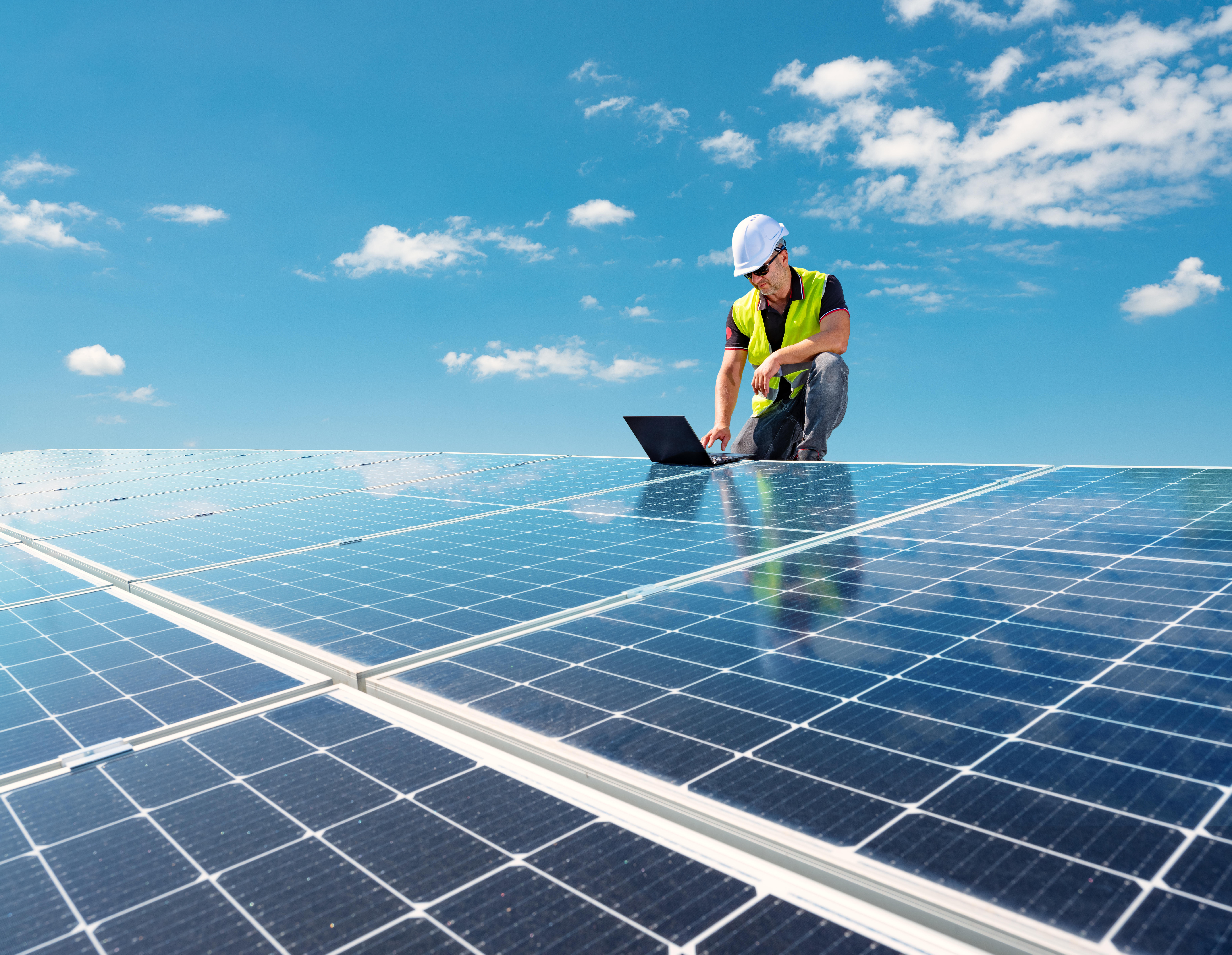 Electrician engineer working at a photovoltaic farm, checking and maintenance equipment at industry solar power 