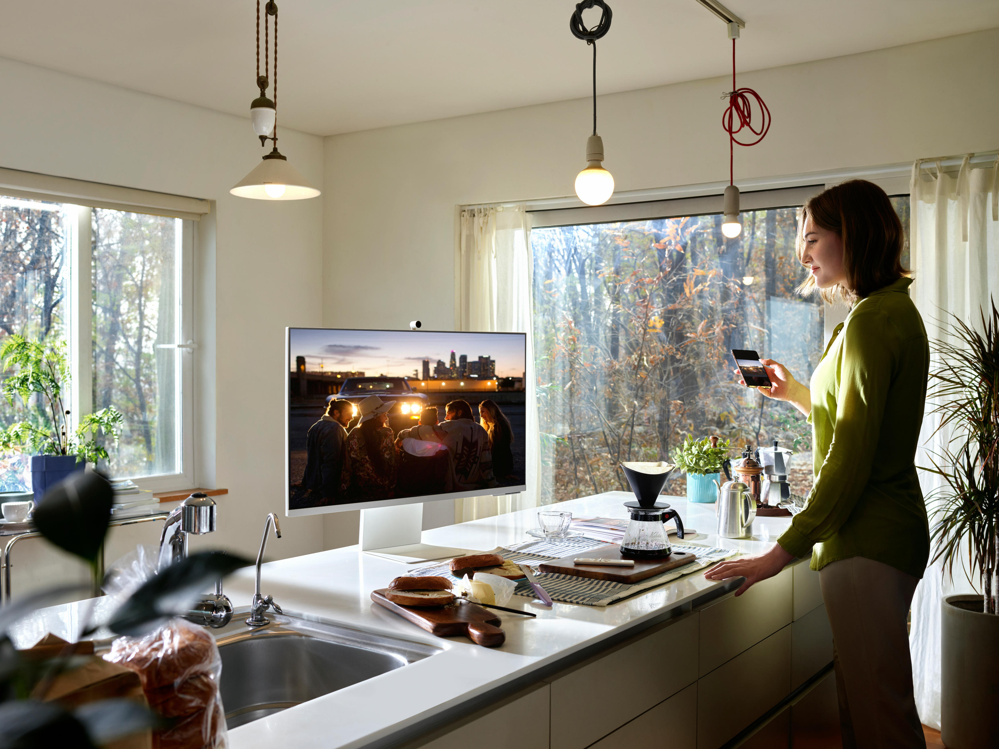 Woman with Samsung M8 in kitchen 