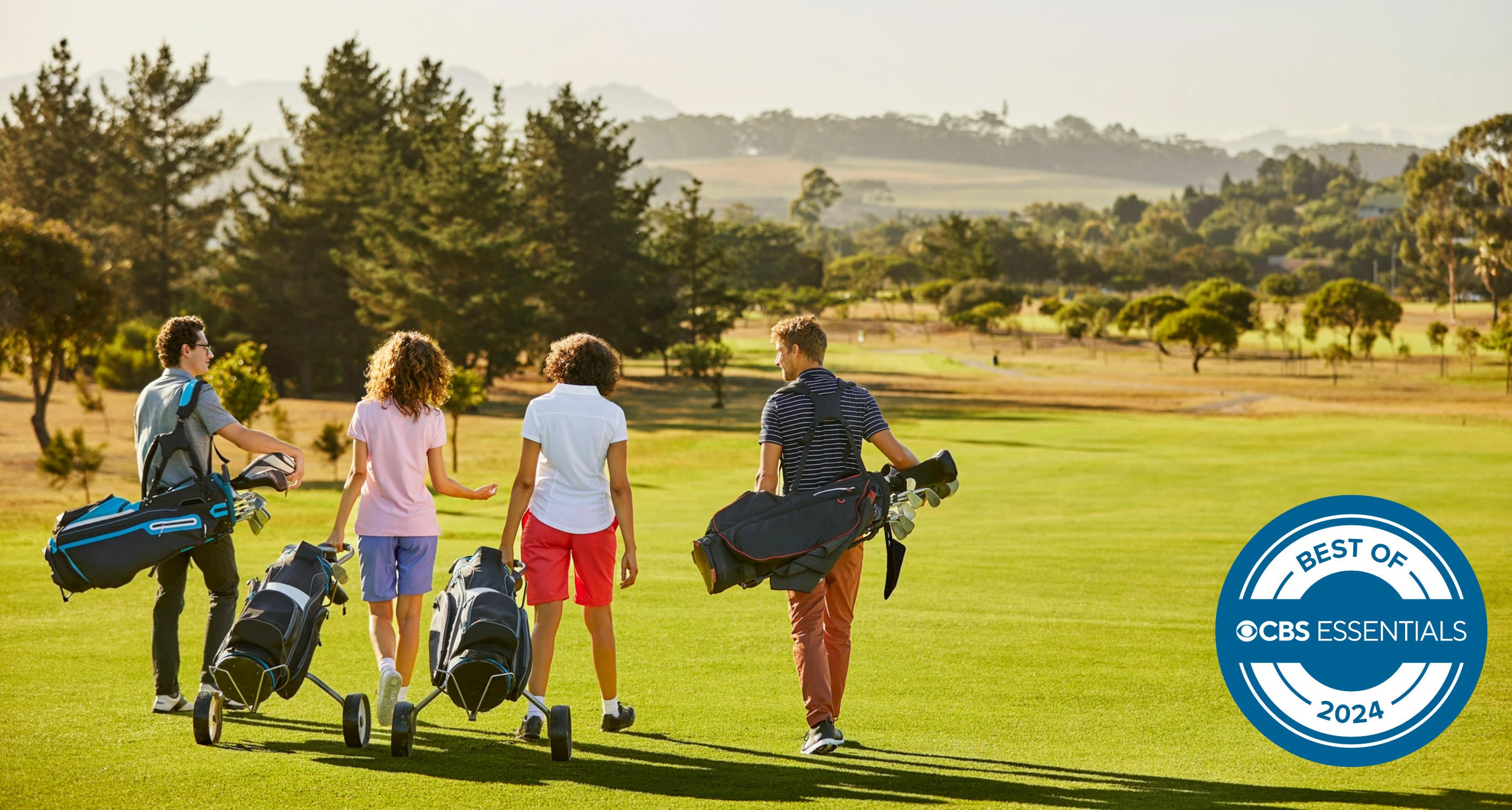 Friends at golf course against sky on sunny day 