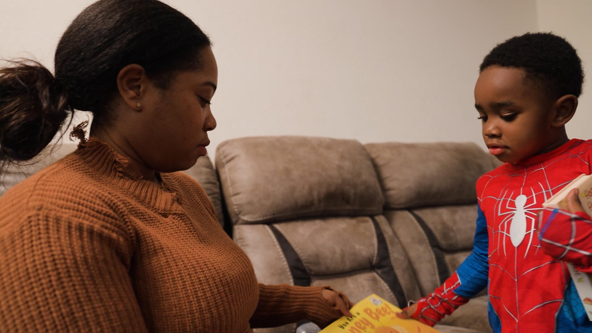 ​Alexis Lewis helps her son find a book to read. 