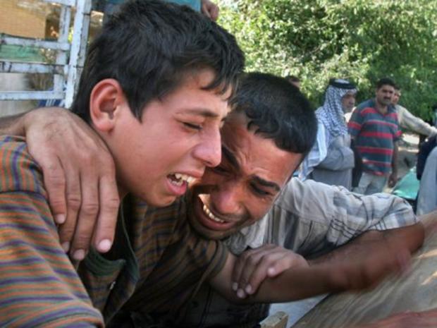 Abbas, left, cries for his brother Zaman who was killed in a drive-by shooting 