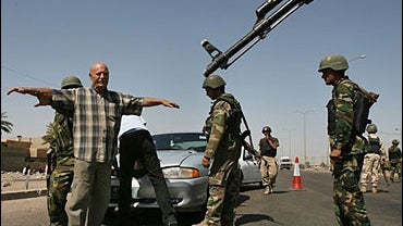 Iraqi Interior Ministry commandos frisk a motorist 