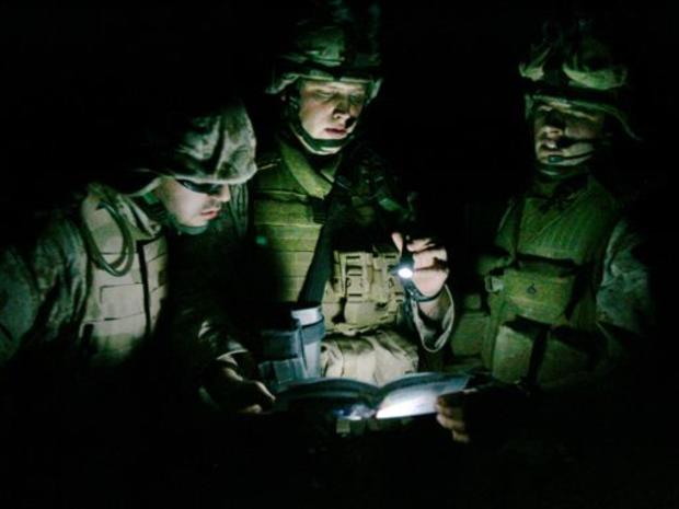 U.S. Marine Cpl. Brad Bruce, center, of LaPorte, Ind., Cpl. Tyler Warndorf, right, of Hebron, Ky., and a translator, study a map before a patrol, in Ramadi 