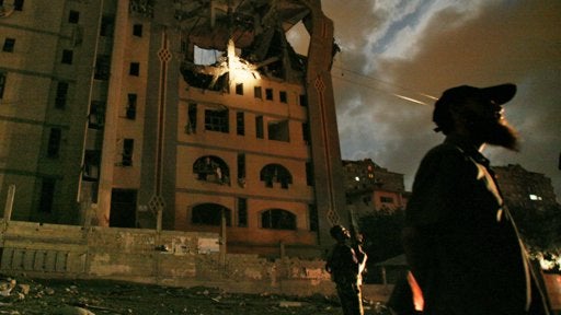 Armed Palestinian men stand beneath the Foreign Ministry building in Gaza City 