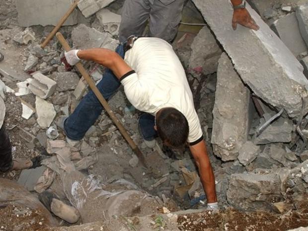 A Lebanese citizen clears debris to release the body of a victim buried in the southern town of Tyre, Lebanon 