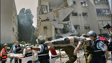 Rescue workers evacuate a seriously wounded man from a building 
