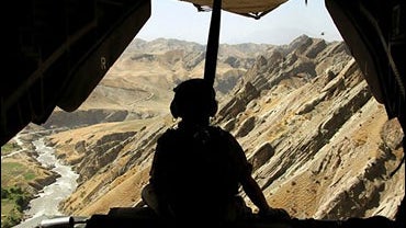 A German soldier sits in an open helicopter during a flight to Feisabad 