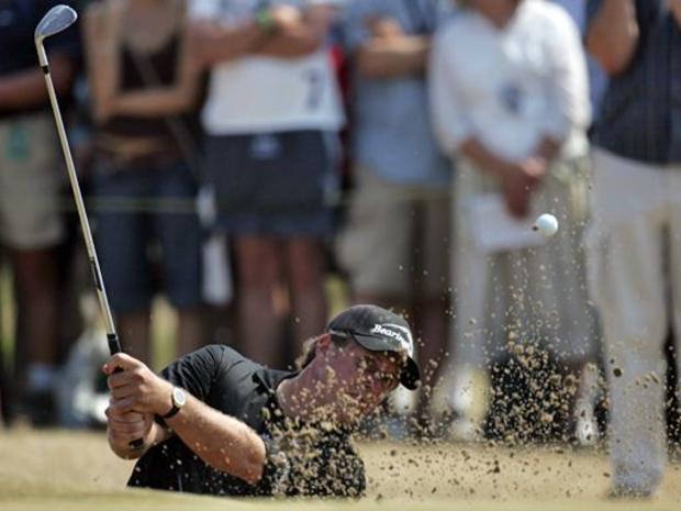 Phil Mickelson from the U.S. blasts out of a bunker on the 6th hole during the opening round of the British Open 
