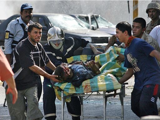 An Iraqi suffering from a serious head wound is taken from the scene of a massive car bomb, Tuesday morning, Aug. 1, 2006, in Baghdad, Iraq. 