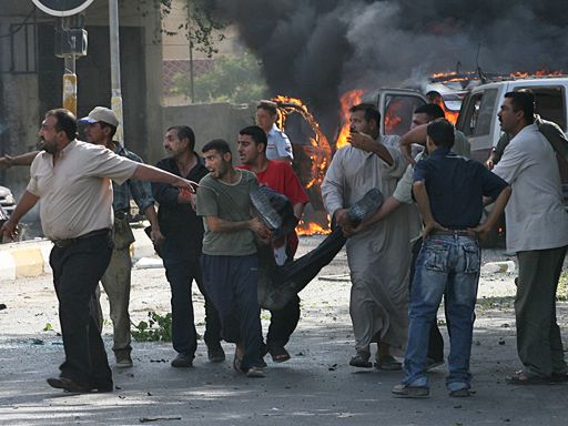 Iraqis wounded in a massive car bomb are carried away from the scene, Tuesday morning, Aug. 1, 2006, in Baghdad, Iraq. 
