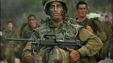 Israeli soldiers from a combat engineer unit walk along a road crossing back from the Lebanese side of the border near the northern Israel town of Metulla 