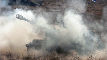 Smoke and dust rises after an Israeli artillery piece fired towards southern Lebanon 