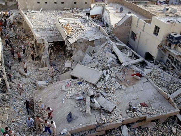 An Iraqi boy with his mother looks at the damaged mosque 