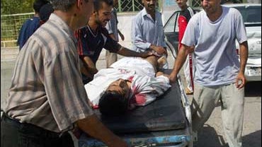 Iraqis mourn over the body of their relative as they wheel him into the morgue of a hospital in the restive city of Baquba north of Baghdad 18 August 2006. 