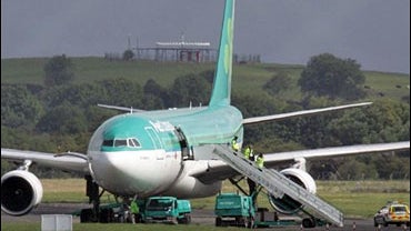 Security and airport officials leave the Aer Lingus plane following a threat against the aircraft at Shannon International Airport, Limerick Ireland 