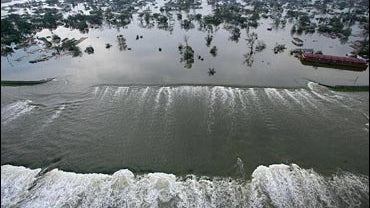 Floodwaters from Hurricane Katrina pour through a levee along Inner Harbor Navigational Canal, also known as the Industrial Canal, near downtown New Orleans, Louisiana, Aug. 30, 2005. 