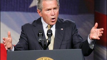 President Bush, left, is applauded by Georgia Gov. Sonny Perdue after he delivered a speech on the global war on terror at a Georgia Public Policy Foundation event at the Cobb Galleria Center in suburban Atlanta 