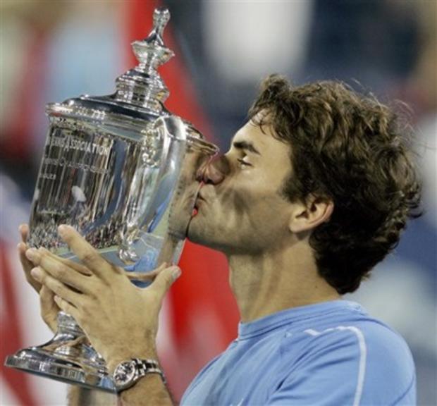 Roger Federer, of Switzerland, kisses the men's singles championship trophy after defeating Andy Roddick 