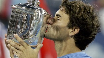 Roger Federer, of Switzerland, kisses the men's singles championship trophy after defeating Andy Roddick 