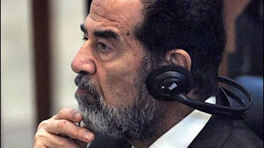 Former Iraqi President Saddam Hussein listens to defence testimony during his trial on genocide charges at the fortified Green Zone in Baghdad, Wednesday, Sept. 13, 2006. 