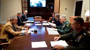 President George W. Bush speaks during a video teleconference with Vice President Dick Cheney, on screen, and military commanders in the Roosevelt Room of the White House, Saturday, Oct. 21, 2006. 