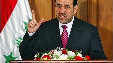 A man waits for his car to be inspected at a checkpoint, manned by the172nd Stryker Brigade Combat Team 