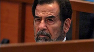 Saddam Hussein listens to a testimony during his ongoing trial inside the heavily fortified Green Zone, in Baghdad, Iraq 