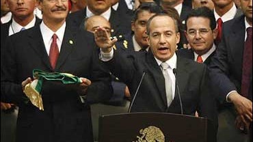 Felipe Calderon, center, is sworn in as outgoing President Vicente Fox, left, holds the presidential sash at the National Congress in Mexico City on Friday Dec. 1, 2006. 