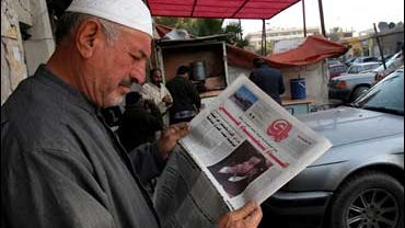 man reads paper about saddam 