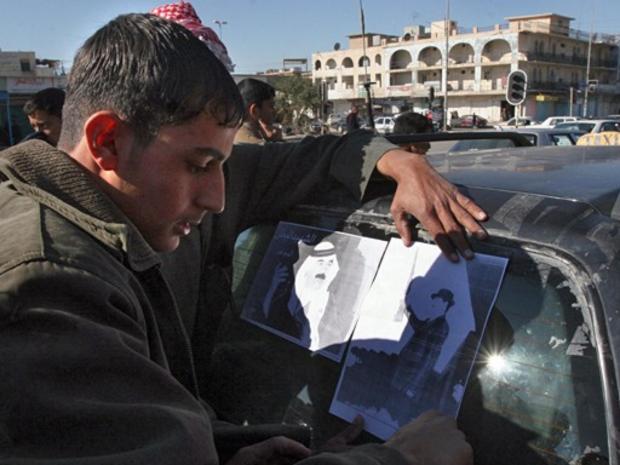 Sunni Arab Iraqis tape portraits of executed former president Saddam Hussein to their taxi, in the Sunni-stronghold of Tikrit, January 3, 2007. 