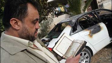 Wasfi Kabha leafs through a partially destroyed Koran 