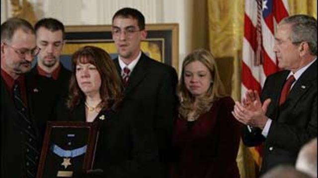 President Bush, right, applauds Marine Cpl. Jason Dunham's family, left, as they take part in a Medal of Honor ceremony, Thursday, Jan. 11, 2007, in the East Room of the White House in Washington 