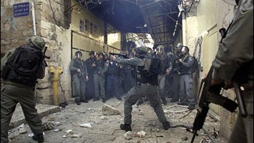 Israeli border police officers prepare to fire tear gas canisters towards Palestinian stonethrowers during clashes in the narrow alleyways of east Jerusalem's Old City, Friday, Feb. 9, 2007. 