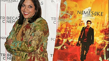 Mira Nair posing in front of poster of her latest film 