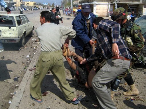 People evacuate a wounded person from a car bombing scene in Kirkuk 