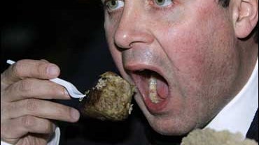 British performance artist Mark McGowan eats a piece of Corgi dog (in picture) in a busy street in London Tuesday May 29, 2007. 