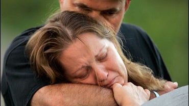 Greg and Missey Smith listen to a speaker during a candlelight vigil for their daughter Kelsey Smith at Shawnee Mission West High School 