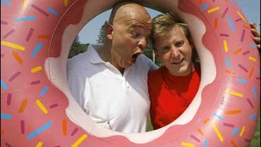 Tim Kavanagh, left, as Homer Simpson, and Brock Rutter as Bart Simpson, pose inside a fake doughnut in Springfield, Vt., Tuesday, June 19, 2007. Springfield, Vt., likes to think itself a real-life alter ego to the home of "The Simpsons." 