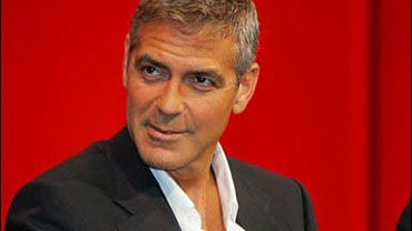 George Clooney listens to reporters' questions during a press conference in Tokyo 