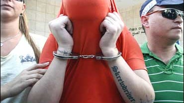 Israeli police lead a handcuffed suspect of an alleged neo-Nazis gang 