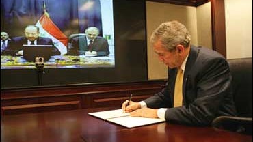 President George W. Bush signs agreement via video conference with Iraq Prime Minister Nouri al-Maliki 