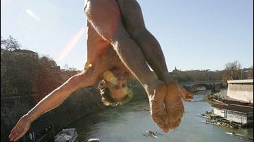 Italian Marco Fois dives into the Tiber River from the 18 meter (59 feet) high Cavour Bridge in Rome, Tuesday, Jan. 1, 2008, to celebrate the New Year. 