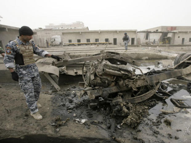 Iraqi police inspect the scene where a truck loaded with rockets exploded as policemen were defusing it 