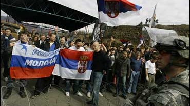 US soldier stands guard in front of Serbs 