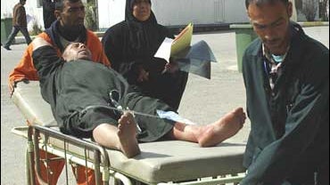 Medics wheel a wounded pilgrim in a hospital in Baghdad, Iraq 