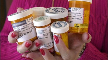 Hands hold prescription pill bottles 