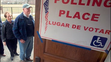 Voters wait outside a polling place to vote in the presidential primary, 
